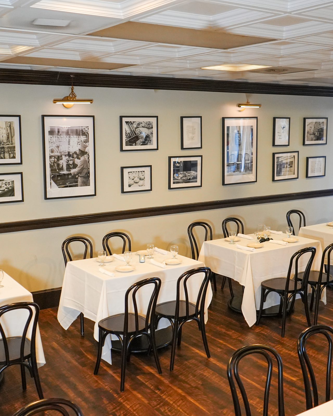 Tables set under the tin ceiling, photographs along the wall