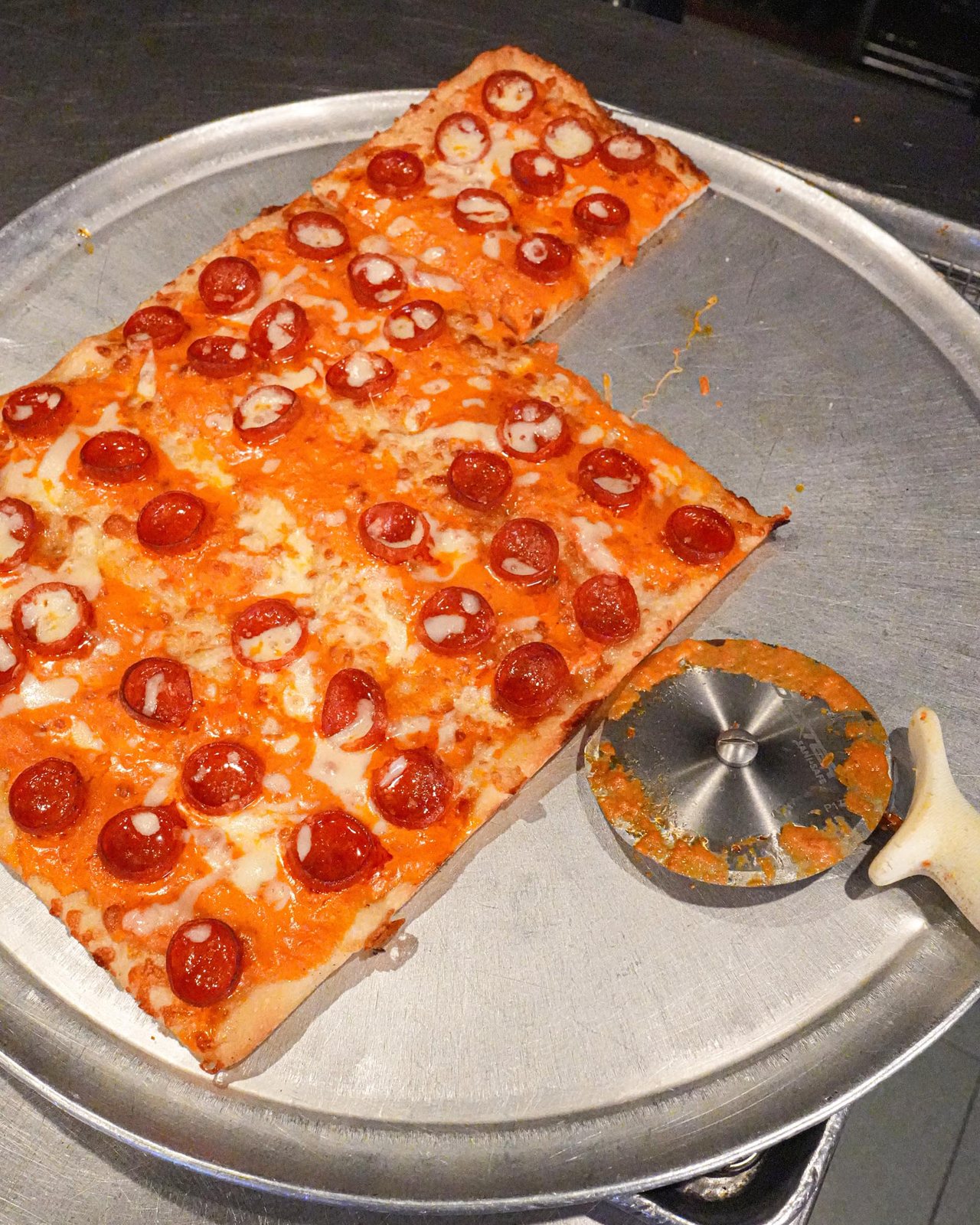 Pepperoni Sicilian, cut into squares on the pan