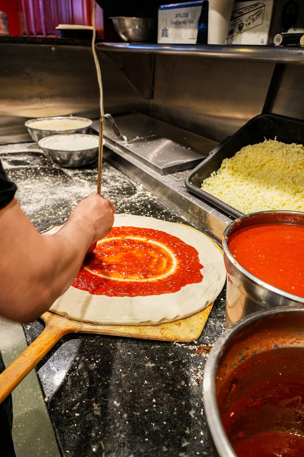 Saucing a pie on the peel